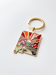 a keychain with an image of a hot air balloon flying over the mountains