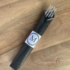 a close up of a piece of metal on a wooden table with a pen and scissors