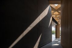 an empty hallway between two buildings with columns