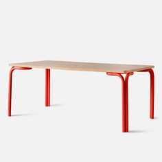 a wooden table with red legs on a white background