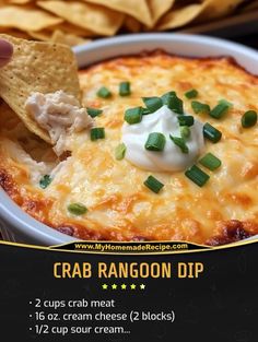 a hand dipping a tortilla chip into a bowl of crab rangoon dip