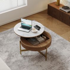 a coffee table with a laptop and phone on it in front of a window next to a rug