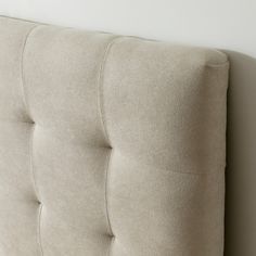 an upholstered headboard is shown against a white wall