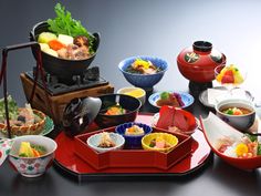 a table topped with bowls and plates filled with food