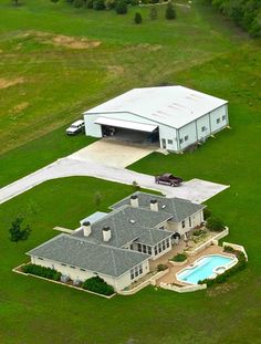 an aerial view of a large house with a swimming pool in the middle of it