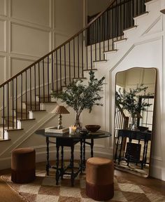 a living room filled with furniture and a stair case next to a table on top of a rug