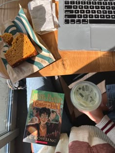 a person sitting at a table next to a laptop computer and a cup of coffee