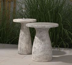 two cement pedestals sitting next to each other in front of some tall green grass