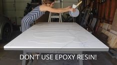 a woman is working on a table in a garage with the words don't use epox resin