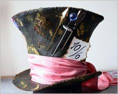 a hat that has some scissors in it and a pink ribbon around the brim