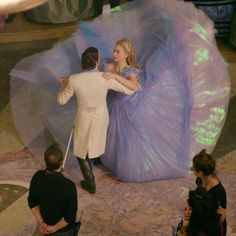 a man and woman dancing in front of an audience at a fashion show, dressed in white