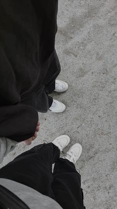 two people standing next to each other with white shoes