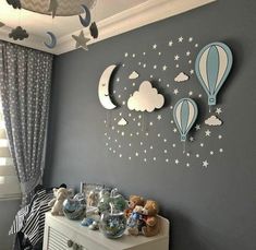 a child's room decorated in blue and white with hot air balloons on the wall