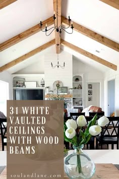 a vase filled with white flowers sitting on top of a wooden table in front of a kitchen