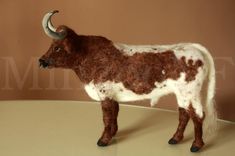 a brown and white cow standing on top of a table