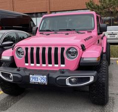 a pink jeep is parked in a parking lot