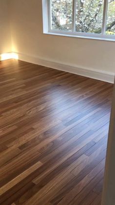 an empty room with hard wood floors and windows