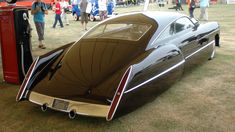 an antique car is parked on the grass