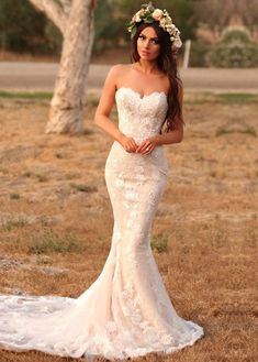 a woman in a wedding dress posing for the camera with her hand on her hip