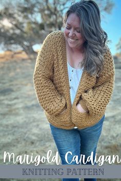 a woman wearing a yellow cardigan standing in the grass with her hands on her hips