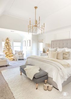 a bedroom decorated for christmas with a large bed and chandelier