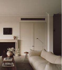 a living room filled with furniture and a fire place in front of a white fireplace