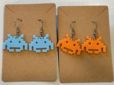 two pairs of earrings made to look like pacman and space invade from the video game