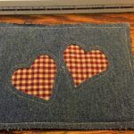 two heart shaped patches are on the back of a laptop