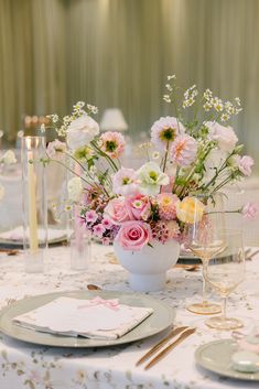 the table is set with pink and white flowers