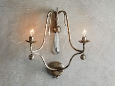 a wall mounted light with three candles on it's arm and two lights in the middle