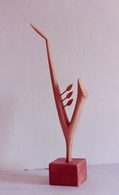 a small wooden sculpture on a white surface