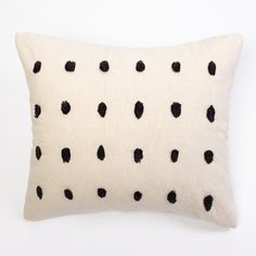 a white pillow with black spots on it