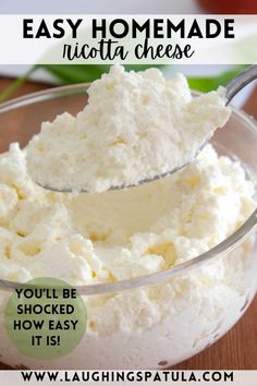 a glass bowl filled with whipped cream on top of a wooden table