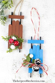 two popsicle sled ornaments are hanging on the wall