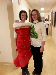 two women standing next to each other in a hallway with christmas decorations on their stockings