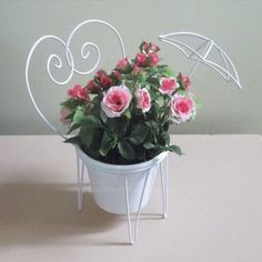 a potted plant with pink flowers and an umbrella shaped decoration in the shape of a heart