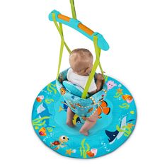 a baby sitting in a blue swing with an ocean theme on the front and bottom