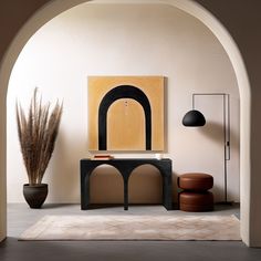 an arch in a room with a table, chair and potted plant next to it