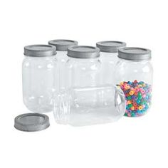 six glass jars with different colored buttons in them and one empty jar on the side