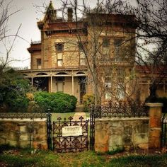 an old house with a gate in front of it