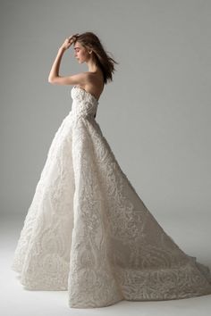 a woman in a wedding dress posing for the camera with her hand on her head