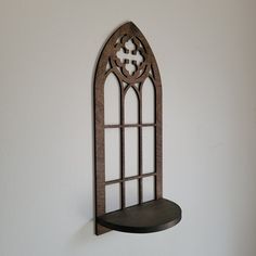 a metal shelf mounted to the side of a wall next to a white wall with a window on it