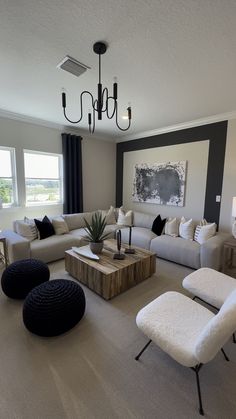 a living room filled with furniture and a chandelier hanging over the top of it