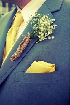 a man in a suit with a boutonniere and flowers on his lapel