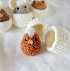 small crocheted stuffed animals sitting on top of a white table covered in fabric