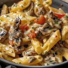 a close up of a plate of pasta with mushrooms and carrots on the side