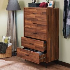 a wooden dresser sitting next to a lamp on top of a hard wood floor