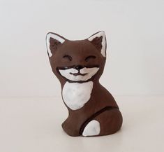 a brown and white cat figurine sitting on top of a table