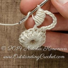 someone is crocheting an object with white yarn in their hand and the thread has been pulled through