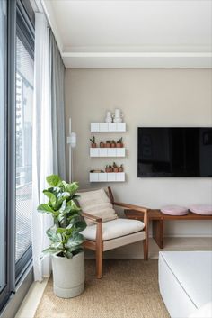 a living room filled with furniture and a flat screen tv mounted to the side of a wall